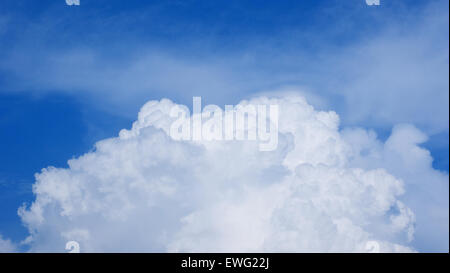 Un ciel bleu clair rempli de nuages de cumulus blancs pelucheux. Les nuages doux et gonflés contrastent magnifiquement avec le bleu profond du ciel, créant une scène extérieure sereine. Banque D'Images