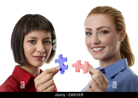 Deux business woman holding le droit jigsaw piece que travailler ensemble Banque D'Images