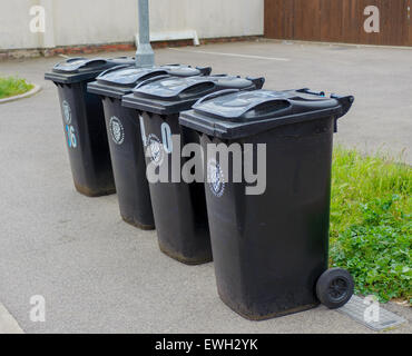 Quatre bacs de wheeling sur le côté de la route en attente d'être vidés Banque D'Images