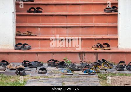 Chaussures à gauche sur marches du temple, Thaïlande Banque D'Images