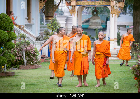 Jeunes moines quittant le Wiharn Luang après la prière du matin au Wat Phra Singh, Chiang Mai, Thaïlande Banque D'Images