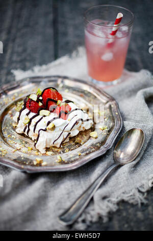 Pavlova aux fraises fait maison avec du chocolat et pistaches Banque D'Images