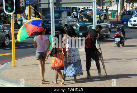 Cape Town, Afrique du Sud - 17 décembre 2010 : Groupe de filles marcher passé jeune garçon mendiant dans les rues. Banque D'Images