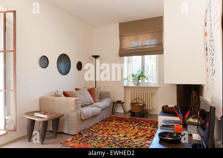 Linge de maison vert canapé d'Habitat dans le salon confortable avec la selle et le tapis de l'Afrique de l'ouest du Maroc. Le linge de maison stores sont de Dominique Banque D'Images