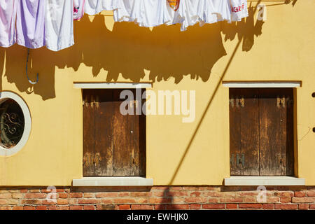 Lave-hanging out en face d'une maison peinte en jaune Lagune de Venise Murano Vénétie Italie Europe Banque D'Images