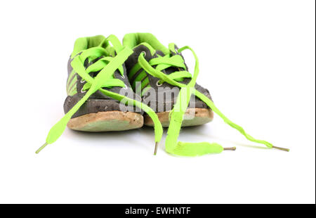 Children's sneakers avec lacets verts sur fond blanc Banque D'Images