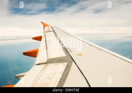 Ailes d'un avion Easyjet en vol sur fond de ciel bleu et nuages Banque D'Images