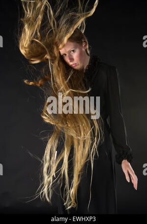 Femme blonde avec du vent soufflant dans les cheveux longs Banque D'Images