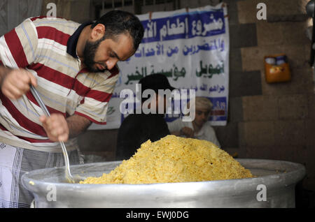 Sanaa, Yémen. 26 Juin, 2015. Un homme yéménite cuit les aliments à un centre de bienfaisance à Sanaa, Yémen, le 26 juin 2015. Le bras humanitaire de l'ONU a annoncé jeudi qu'il fournira un financement d'urgence de l'injection afin d'accélérer les efforts de secours aux civils pris au piège de la guerre au Yémen, où s'affrontent entre les différentes fractions de brassage est une crise humanitaire. © Hani Ali/Xinhua/Alamy Live News Banque D'Images