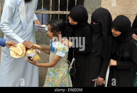 Sanaa, Yémen. 26 Juin, 2015. Un homme yéménite distribue de la nourriture à un organisme de bienfaisance dans le centre de Sanaa, Yémen, le 26 juin 2015. Le bras humanitaire de l'ONU a annoncé jeudi qu'il fournira un financement d'urgence de l'injection afin d'accélérer les efforts de secours aux civils pris au piège de la guerre au Yémen, où s'affrontent entre les différentes fractions de brassage est une crise humanitaire. © Hani Ali/Xinhua/Alamy Live News Banque D'Images