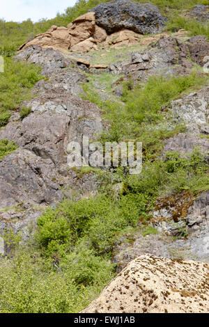 Grand rocher de tuf rock tombé de couche au-dessus de colline sur l'Islande Banque D'Images