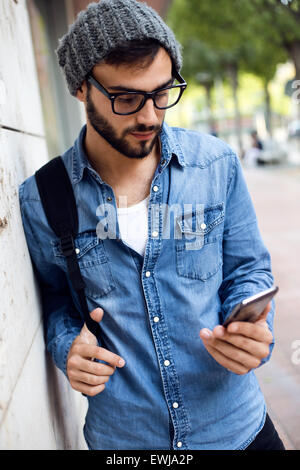 Portrait plein air de jeune homme moderne avec téléphone mobile dans la rue. Banque D'Images