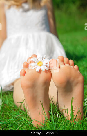 Pieds d'un enfant sur l'herbe verte Banque D'Images