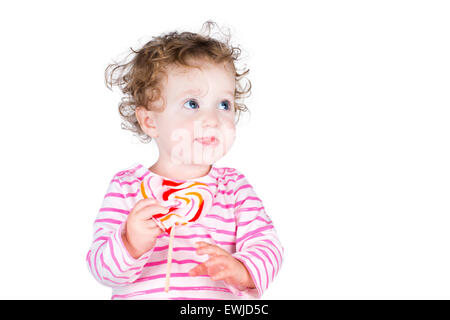 Cute girl bouclés avec un bonbon en forme de coeur, isolated on white Banque D'Images