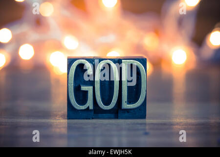 Le mot Dieu écrit en metal vintage type typographique sur un doux fond rétroéclairé. Banque D'Images