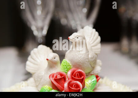 Deux colombes blanches sur gâteau de mariage mariée et le marié fond noir isolé Banque D'Images