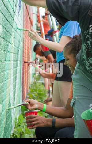 Detroit, Michigan - Jeunes adultes peindre le mur d'un bâtiment dans le sud-ouest de Detroit. Banque D'Images