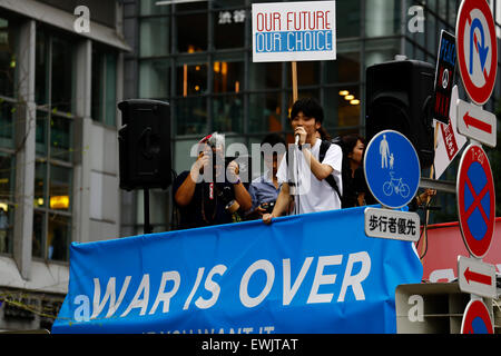 Aki Okuda chef de l'action d'urgence pour les élèves de la démocratie libérale-s (SEALDs) appelle à protéger le pacifiste de l'article 9 de la Constitution japonaise dans le quartier commerçant de Shibuya le 27 juin 2015, Tokyo, Japon. Environ 000 personnes ont manifesté devant la gare de Shibuya à l'extérieur de l'intersection célèbre contre le Premier ministre Abe's réinterprétation de l'article 9, qui permettrait à la nation pour lutter contre les troupes d'outre-mer. © Rodrigo Reyes Marin/AFLO/Alamy Live News Banque D'Images