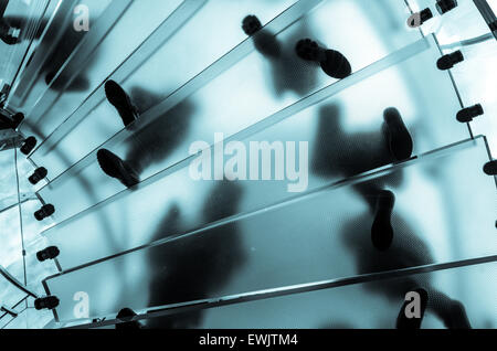 Pieds sur un escalier en verre à la recherche vers le haut d'en bas des escaliers. Escalier est dans un magasin de New York Banque D'Images