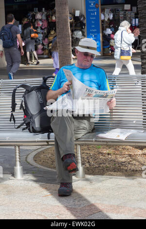 Manly, Australia-June 12e 2015 : Un homme est assis lisant un journal sur le Corso. Le Corso est un endroit populaire pour s'asseoir Banque D'Images