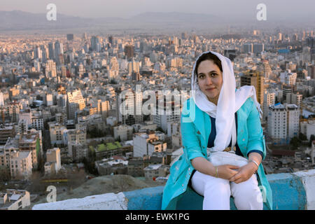 Au coucher du soleil femme perse posant avec toile ville, Téhéran, Iran Banque D'Images