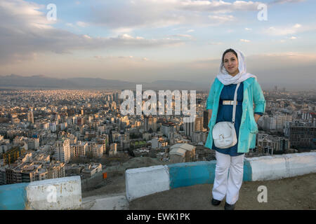 Femme perse avec vue sur la ville de Téhéran au coucher du soleil, la montagne, l'Iran Tochal Banque D'Images