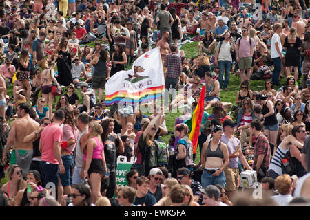 San Francisco, USA. 27 Juin, 2015. Une femme descend un drapeau de l'État de Californie avec des couleurs arc-en-ciel à travers la grande foule à Mission Dolores Park. Crédit : John Orvis/Alamy Live News Banque D'Images