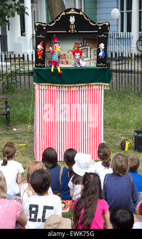 Les enfants regarder un Punch and Judy show traditionnel Banque D'Images