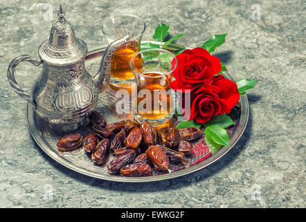 Plateau, dates des fruits et fleurs rose rouge. Jours fériés islamiques décoration. Ramadan kareem. Eid Mubarak. L'hospitalité orientale concept. Banque D'Images