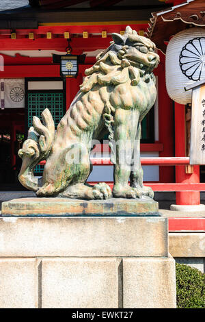 Vue latérale d'une des deux, Komainu, une statue de pierre chien gardien à l'entrée de la principale salle de culte de l'Ikuta culte à Kobe, au Japon. Banque D'Images