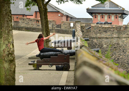 Assis sur touristiques Cannon sur la 17e siècle dans les murs de Derry, Londonderry, en Irlande du Nord. Banque D'Images