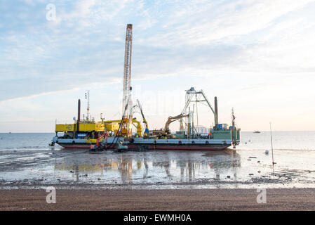 Herne Bay, Kent, UK. 29 Juin, 2015. Le branchement du nouveau câble de Kentish Flats Wind Farm. Le navire de pose de câbles d'installation BoDo située juste à côté de la plage près de Hampton jetée à Herne Bay. Ce matin, un nouveau câble a été relié à la fin du côté de la Ce sera une extension de la Kentish Flats parc éolien offshore au cours des prochains jours. Les pelles de remplissage sont le point d'accès sur le canal qui permet au câble de passer sous la plage. Crédit : Paul Martin/Alamy Live News Banque D'Images