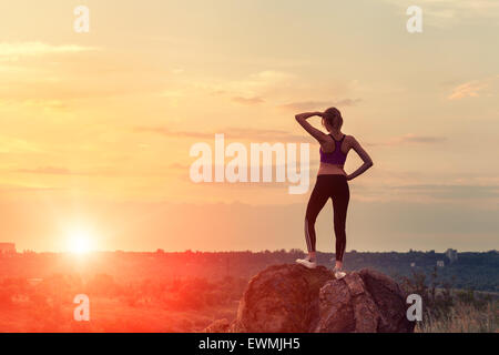 Young woman jusqu'au coucher du soleil en été Banque D'Images