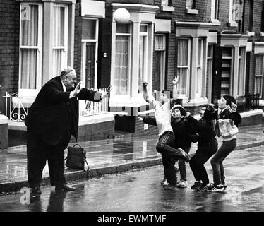 Cyril Smith, député libéral de Rochdale jouer au football avec un groupe de jeunes garçons dans une rue. Dingle, Liverpool, 13 avril 1985. Banque D'Images