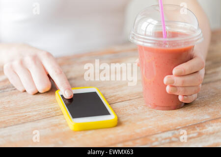 Close up of woman with smartphone smoothie et Banque D'Images