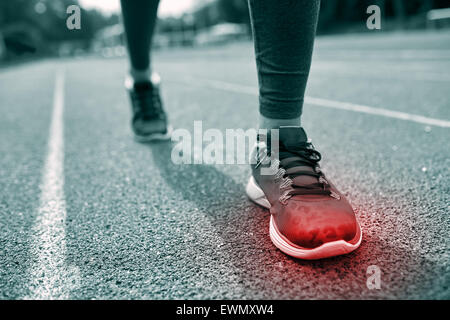 Close up de pieds avec tache rouge tournant sur la voie Banque D'Images