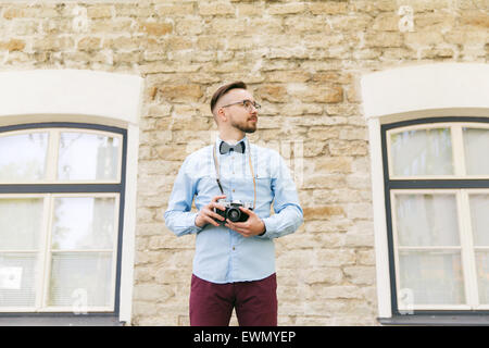 Jeune homme hipster avec caméra film en ville Banque D'Images