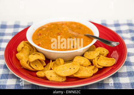 Bol de soupe tortilla au poulet dans un bol blanc sur plaque rouge avec les croustilles de maïs Banque D'Images