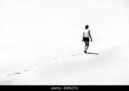 Femme marche sur le désert photo en noir et blanc Banque D'Images