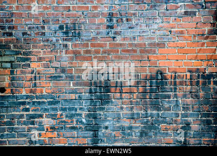 De mur de briques avec différents types de graffitis, usé et patiné de brique et de mortier Banque D'Images