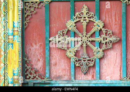 La décoration de style tibétain traditionnel peint en rouge avec porte en bois peint bleu et jaune lattes cadre de porte. Gyantse-Tibet. Banque D'Images