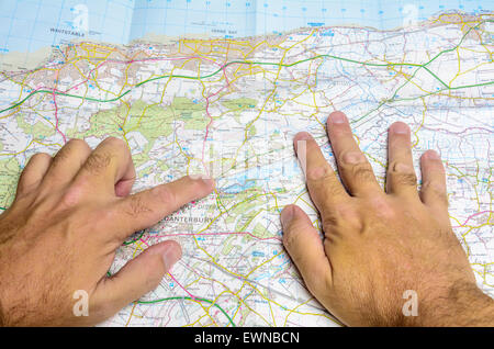 Un homme la lecture d'une carte en papier de l'Ordnance Survey dépliée tandis qu'à la recherche de lieux dans le Kent, Angleterre, Royaume-Uni. Banque D'Images