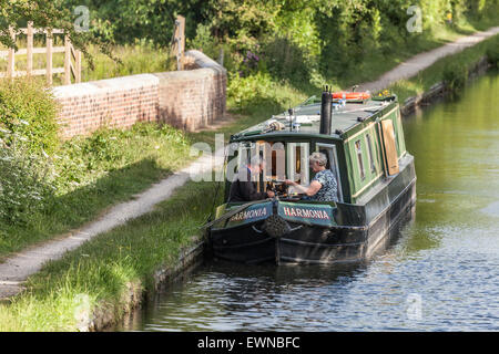 Couple assis sur un chaland amarré sur le côté de l'Birmingham-Fazeley canal dans le centre de l'Angleterre, Royaume-Uni Banque D'Images