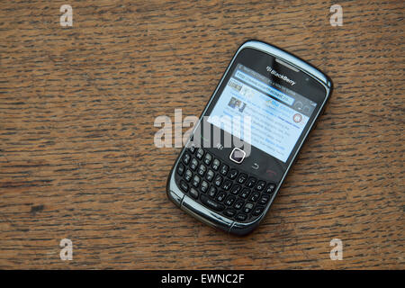 Sur une surface en bois à grain fin un smartphone Blackberry Curve 8320 montrant un bleu pâle site web dans le navigateur Banque D'Images