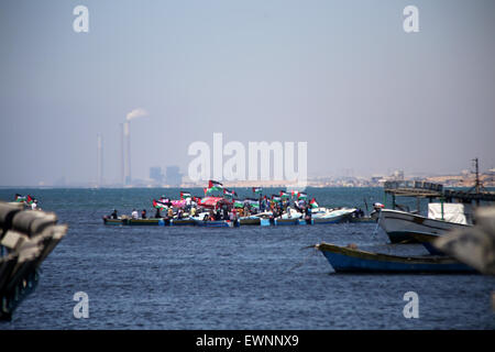 Gaza, la Palestine. 29 Juin, 2015. Palestiniens équitation bateaux tenir des drapeaux palestiniens au cours d'une manifestation contre le blocage israélien d'un bateau de militants étrangers d'atteindre Gaza, au port de la ville de Gaza. © Ibrahim Khatib/Pacific Press /Alamy Live News Banque D'Images