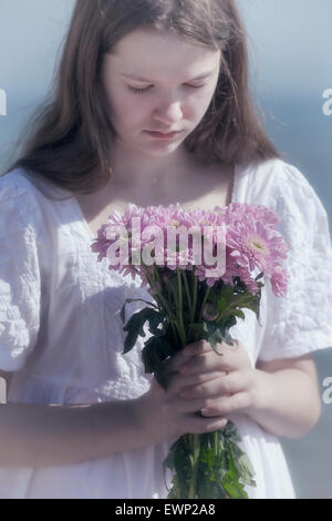 Une jeune fille tenant un bouquet de fleurs Banque D'Images