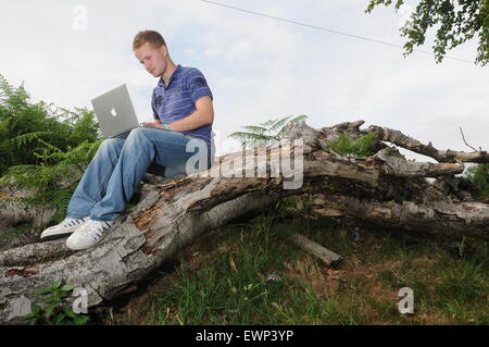 Un homme utilise une connexion internet à haut débit à l'extérieur dans un cadre rural. Banque D'Images