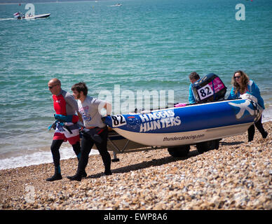 Équipage de bateau, porter leur catamaran gonflable rigide avant une course de bateau de puissance le 5ème prb mis à l'dans le Solent Banque D'Images