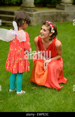 Old Westbury, New York, USA. 28 juin 2015. Lori Belilove & l'Isadora Duncan Dance Company de donner des leçons de danse pour enfants, dans les jardins de la vieille ville historique de Westbury Gardens, un Long Island Gold Coast estate, pour son songe d'une nuit d'événement. Membre de la compagnie de danse est illustré avec jeune fille portant des ailes de fées. Credit : Ann E Parry/Alamy Live News Banque D'Images