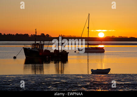 L'estuaire de Swale, Kent, UK. 30 Juin 2015 : la météo. Une lueur orange magnifique lorsque le soleil se lève dans un ciel clair matin calme, plus de bateaux amarrés dans la rigole de Harty ferry près de l'estuaire. L'air chaud de l'Afrique est réglé pour balayer vers le nord et prendre la température plus de 30°C le Mercredi avec des gens avertis de rester à l'intérieur Photo : Alan Payton/Alamy Live News Banque D'Images